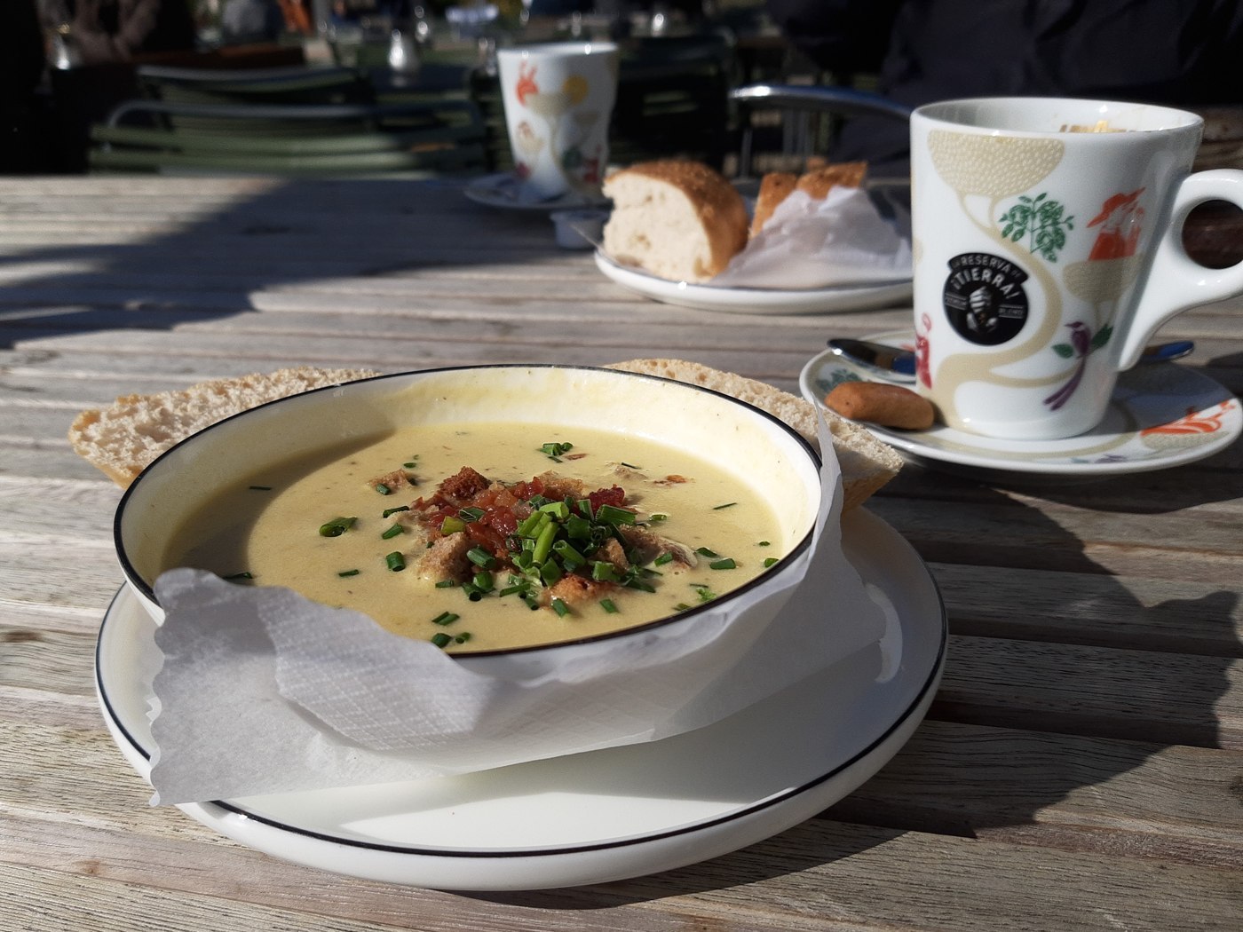 Cremige helle Kartoffelsuppe mit Speckstückchen und grüner Petersilie