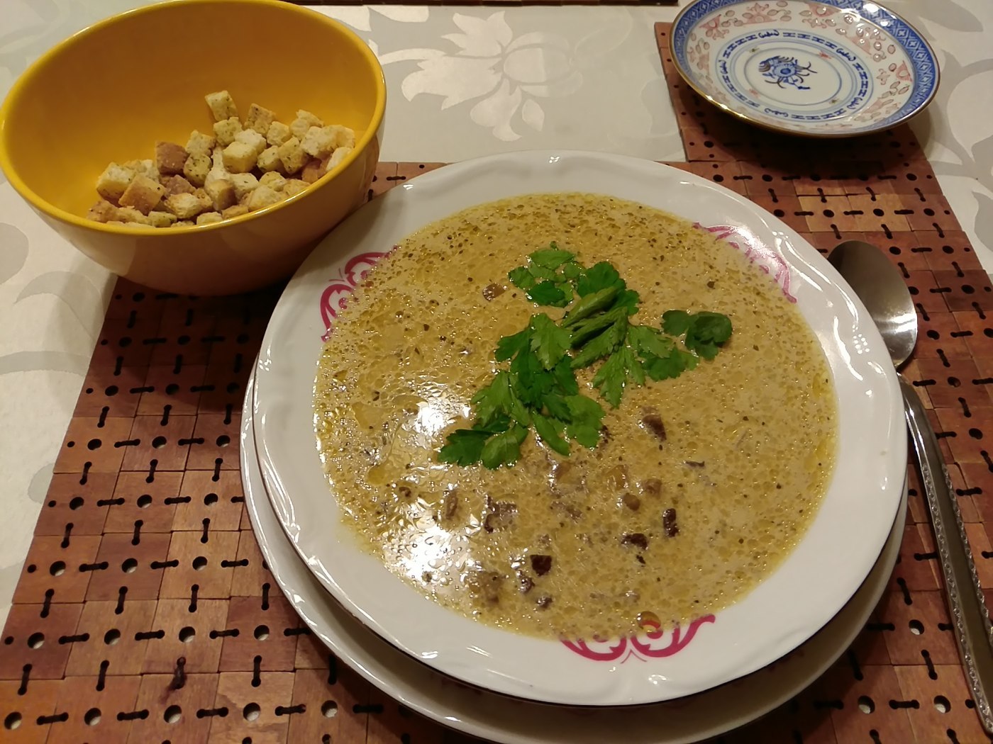 Cremige Pilzsuppe mit kleinen Champignonstücken und Petersilie