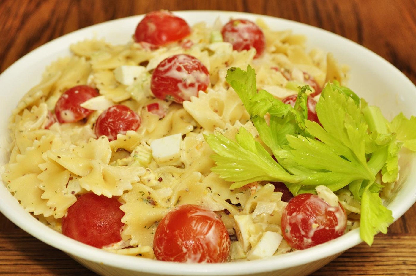 Schleifennudelsalat mit roten Kirschtomaten und kleinen Mozzarellastücken
