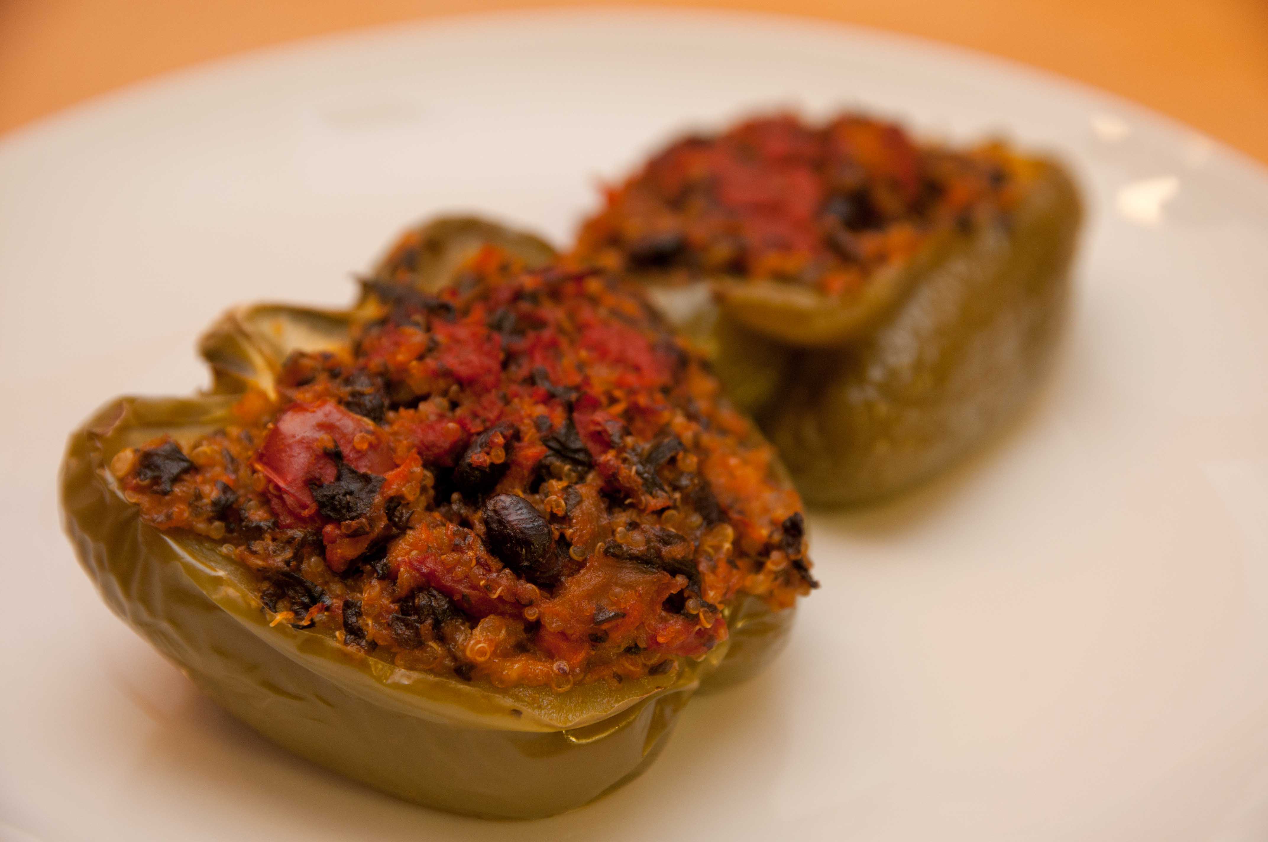 Grüne Paprikahälften mit Quinoa, schwarzen Bohnen, Tomaten und Spinat gefüllt