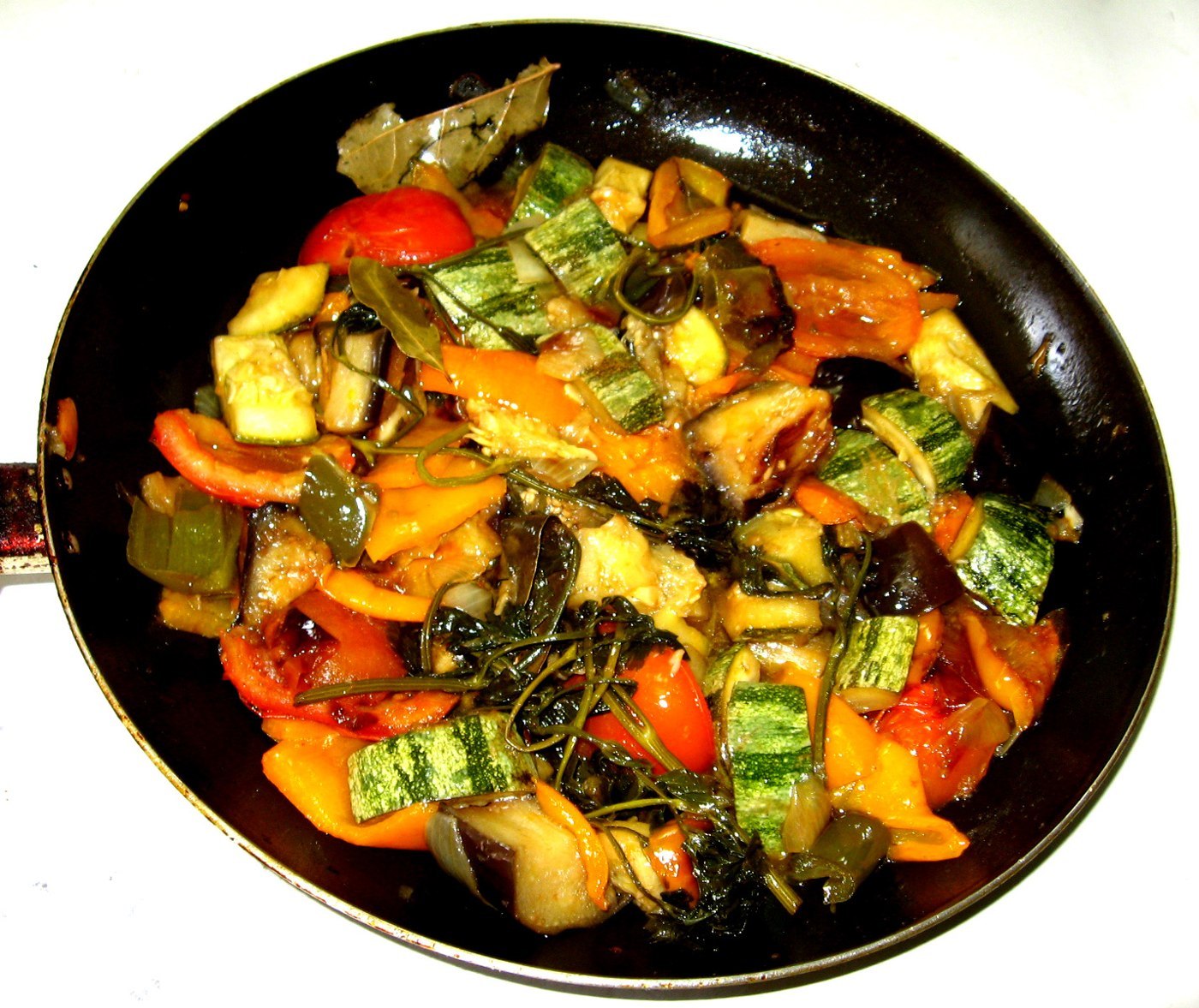 Stückige Aubergine, Zucchini, rote und gelbe Paprika in einer Gemüsepfanne
