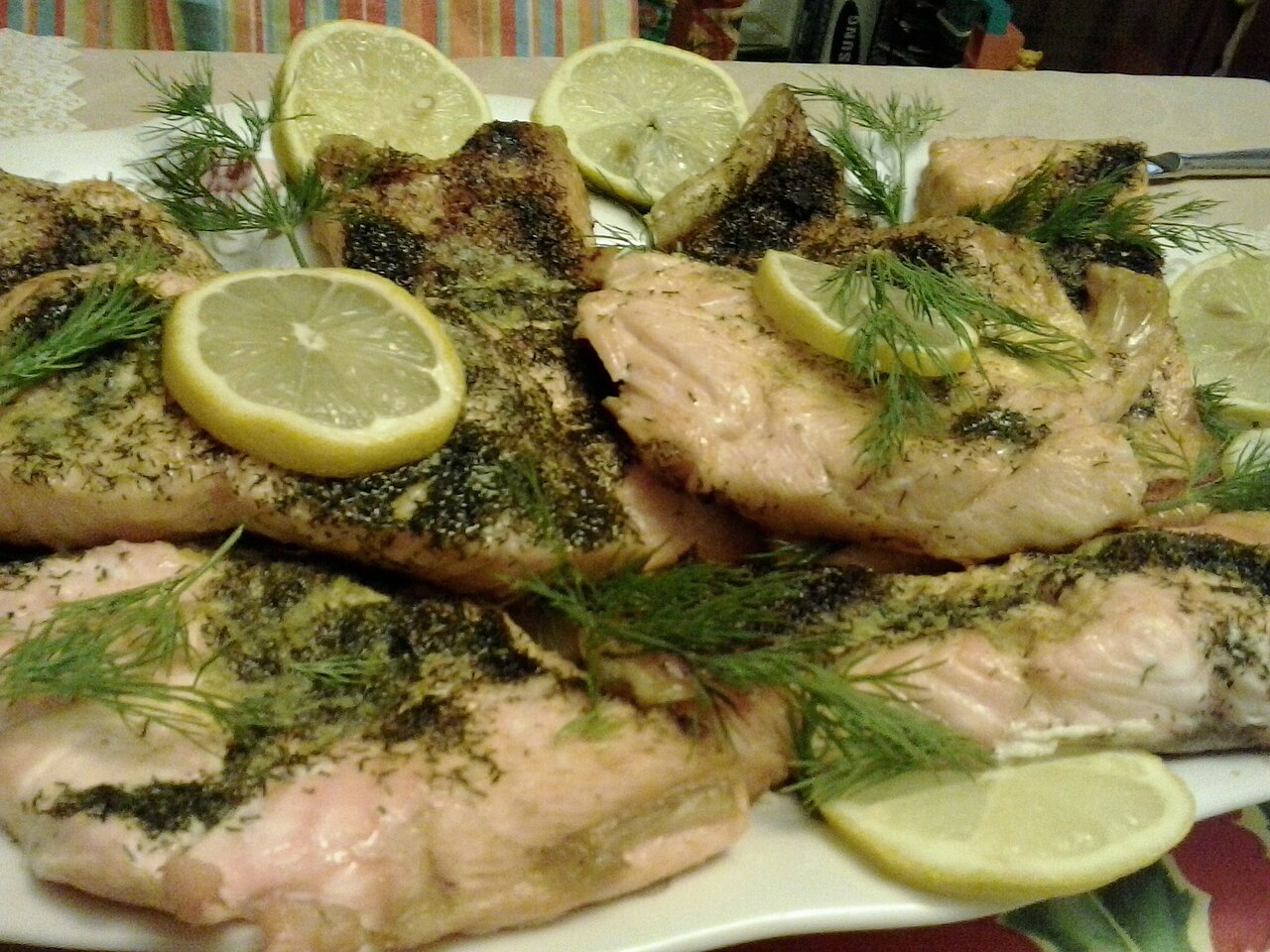 Gegarte Lachsfilets mit Zitronenscheiben und frischem Dill