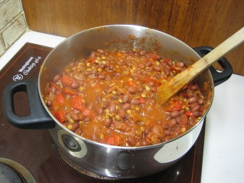 Rotes vegetarisches Chili mit Bohnen, Mais und Gemüse in einem Kochtopf