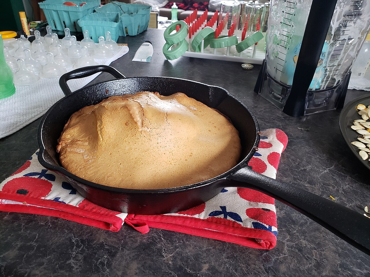 Ein goldbrauner Ofenpfannkuchen mit hohem Rand in einer schwarzen Gusseisenpfanne