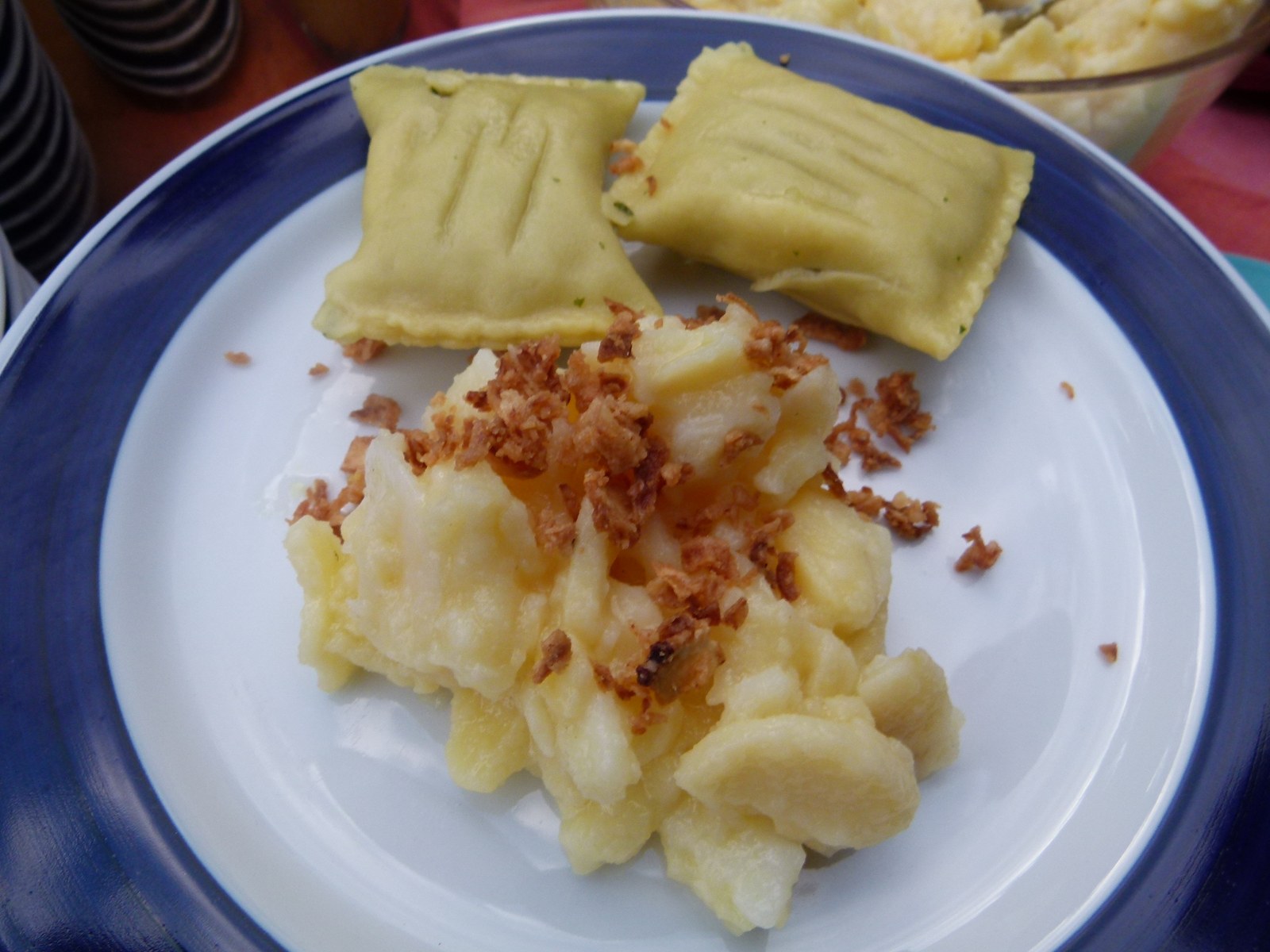 Kartoffelsalat mit gebräunten Zwiebeln und Maultaschen auf einem Teller