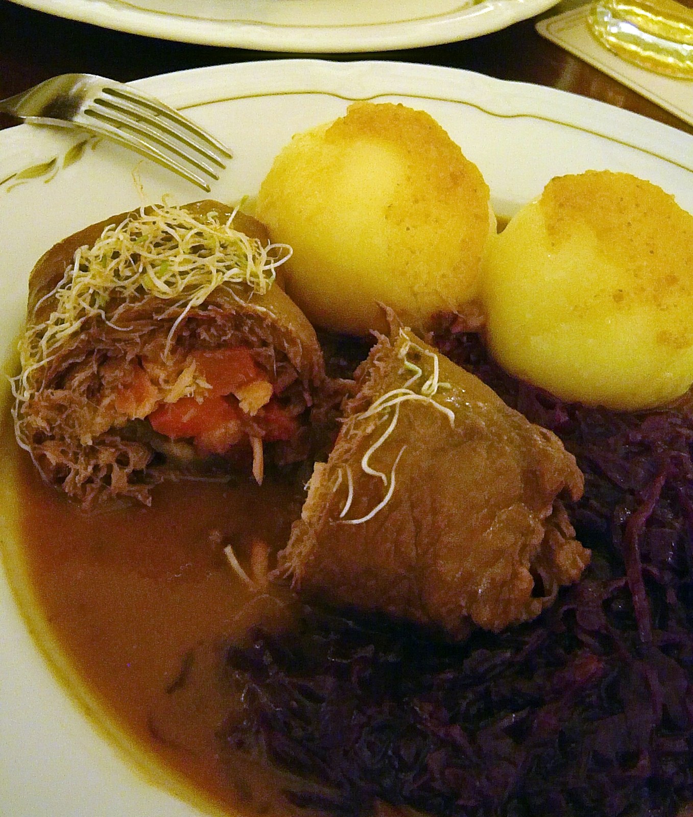 Angeschnittene Rinderrouladen mit dunkler Sauce und Kartoffelklößen