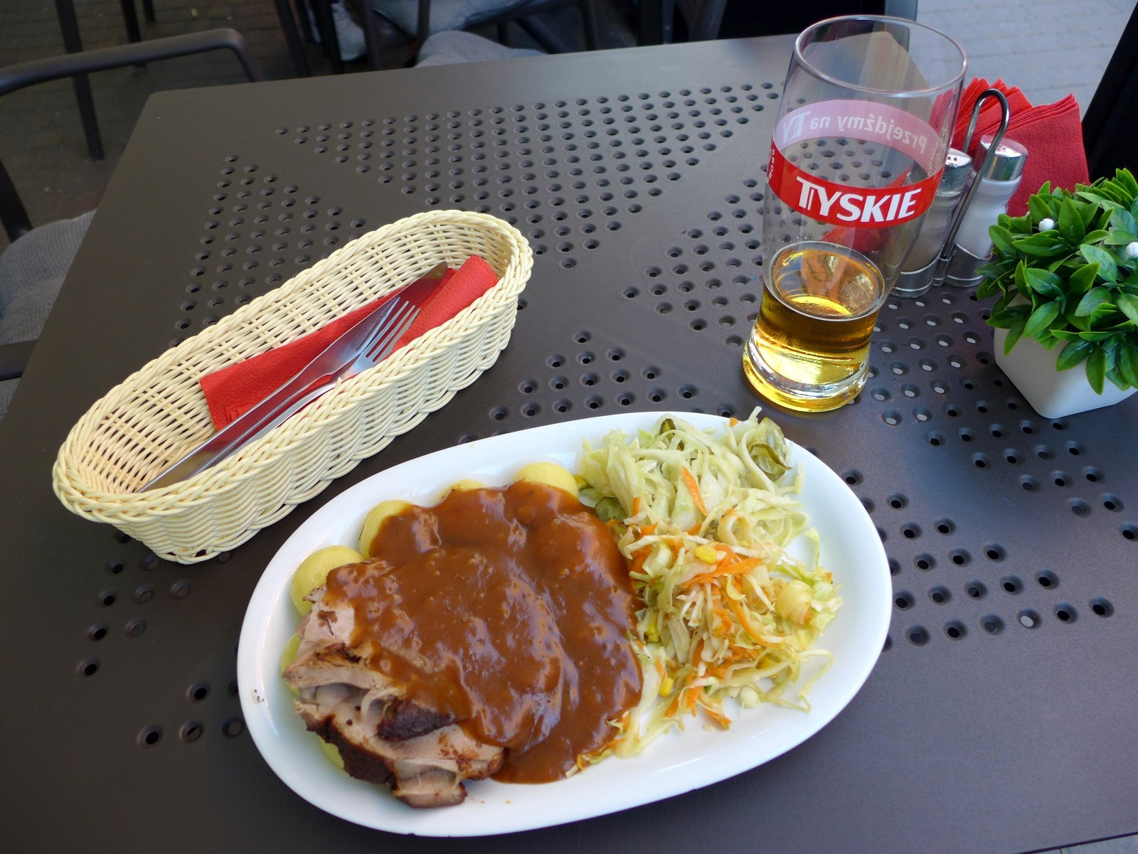 Schweinebraten in Scheiben mit brauner Sauce und Krautsalat
