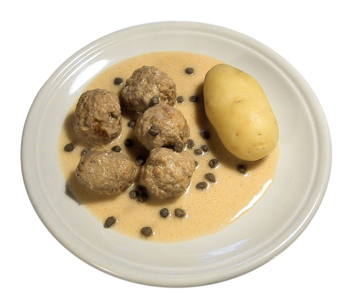 Königsberger Klopse in Kapernsauce neben einer gekochten Kartoffel