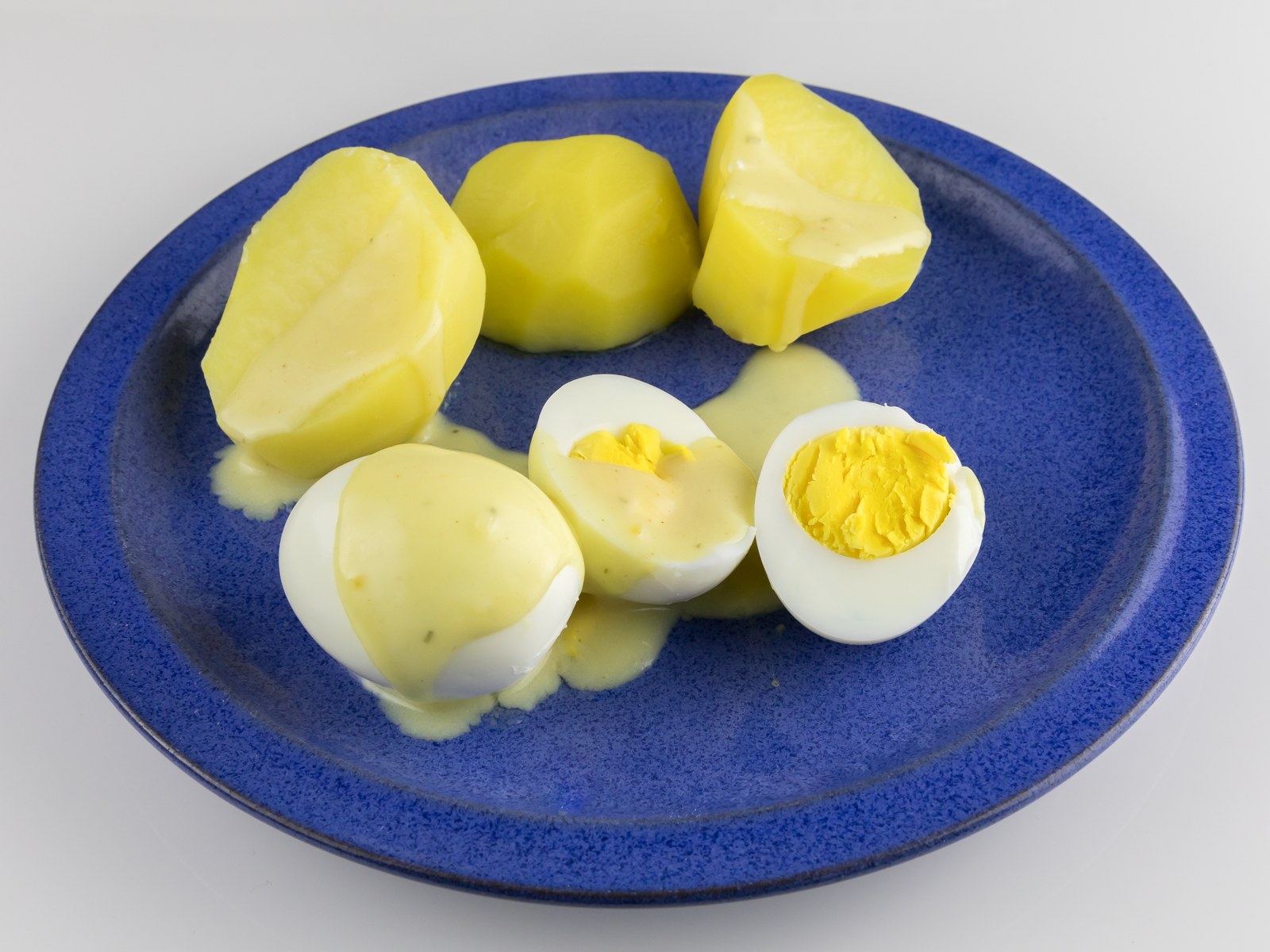 Gekochte Eier in heller Senfsauce mit Kartoffeln