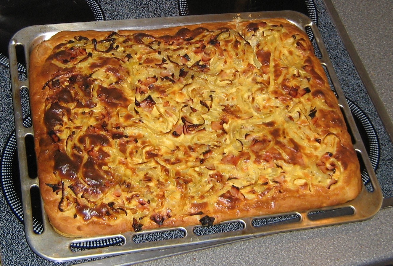 Goldbrauner Zwiebelkuchen auf einem rechteckigen Blech