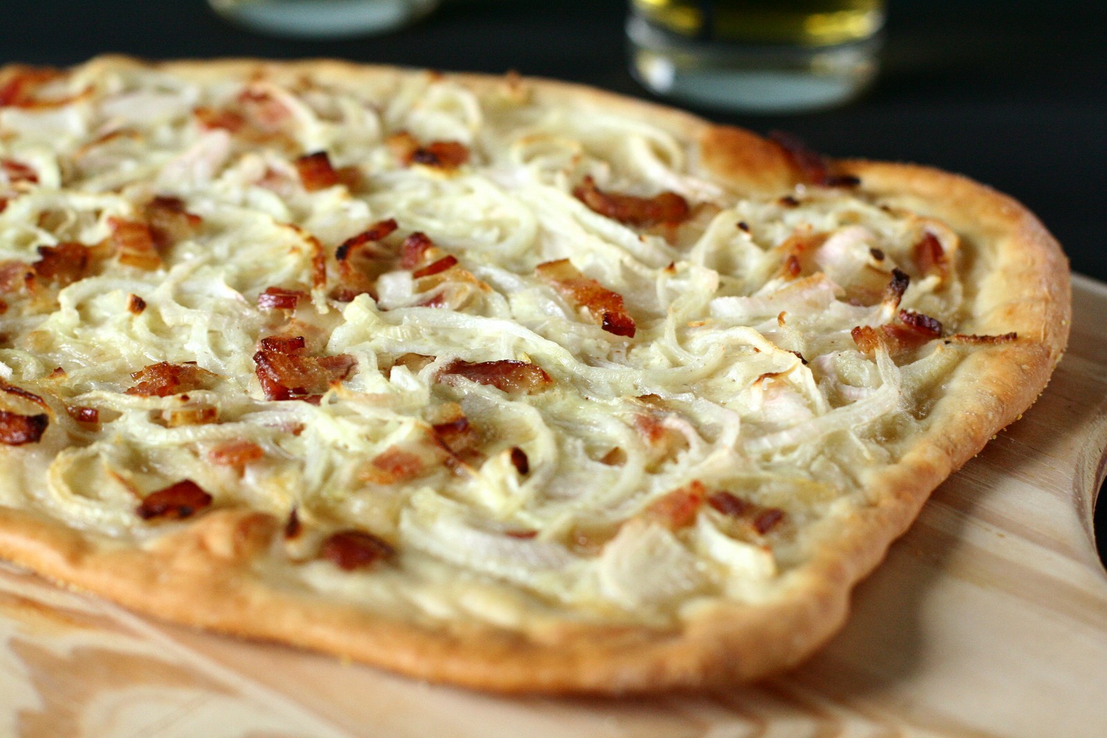 Dünner Flammkuchen mit Creme, Zwiebeln und Speck
