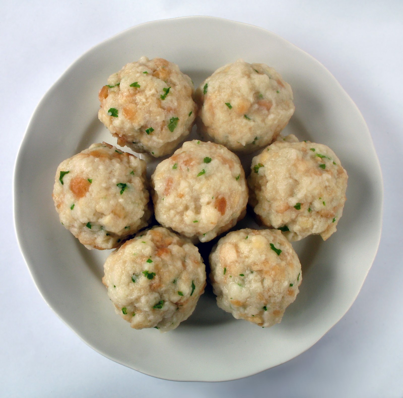 Runde Semmelknödel mit sichtbaren Brotstücken und Petersilie