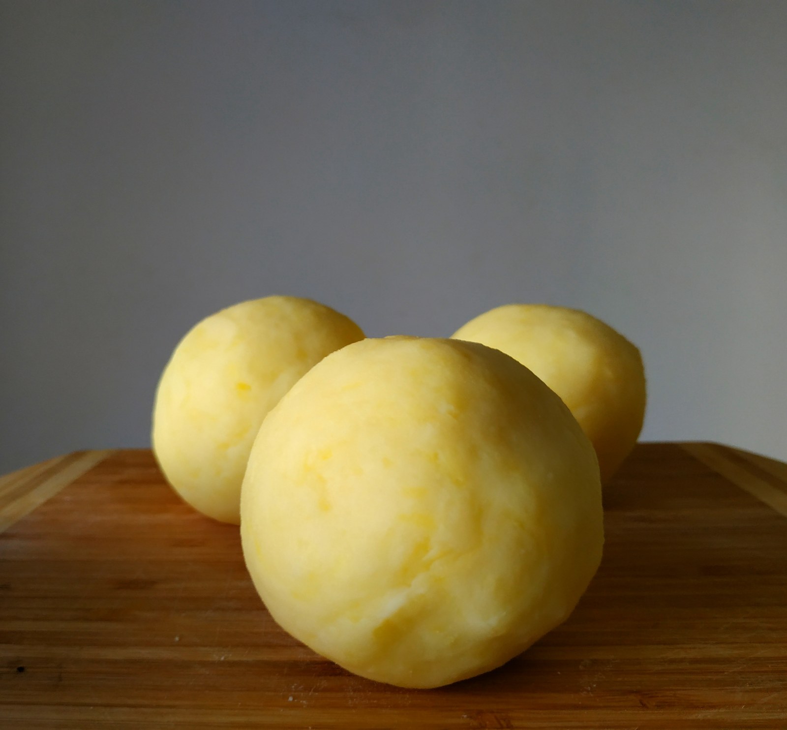 Glatte gelbe Kartoffelklöße auf einem Holzbrett