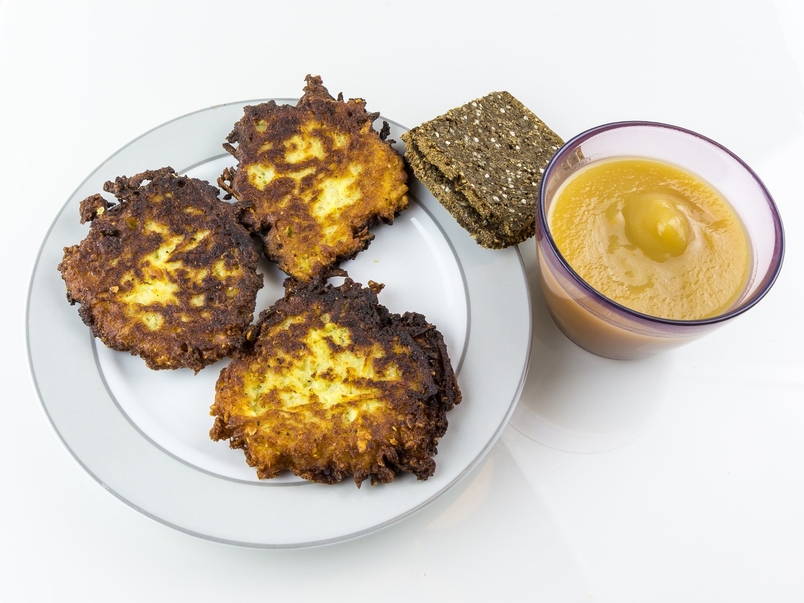 Goldbraune Reibekuchen neben einer Schale Apfelmus