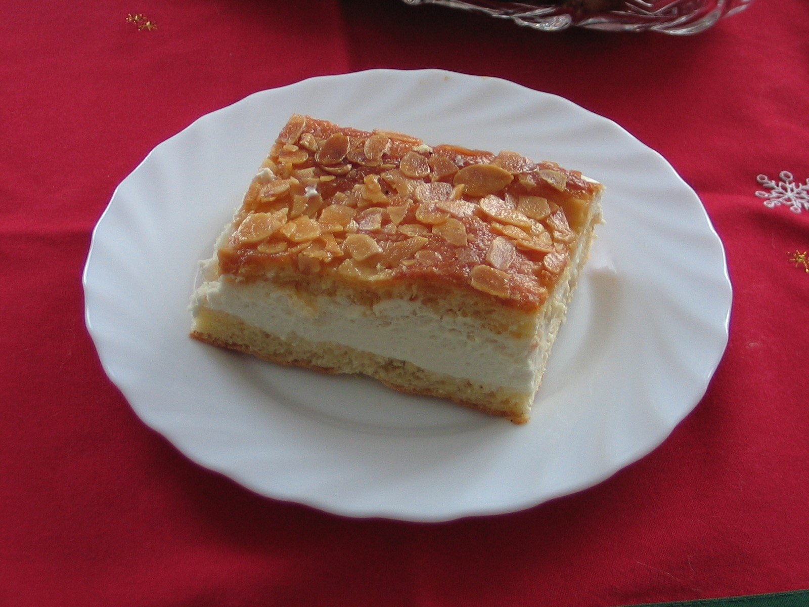 Ein Stück Bienenstich mit Mandelkruste und heller Cremefüllung