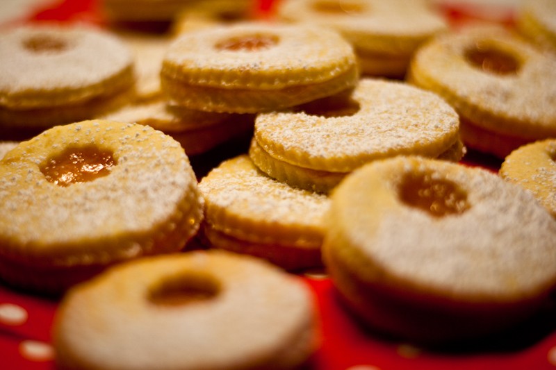 Puderzuckerbestäubte runde Doppelkekse mit rotem Konfitürefenster