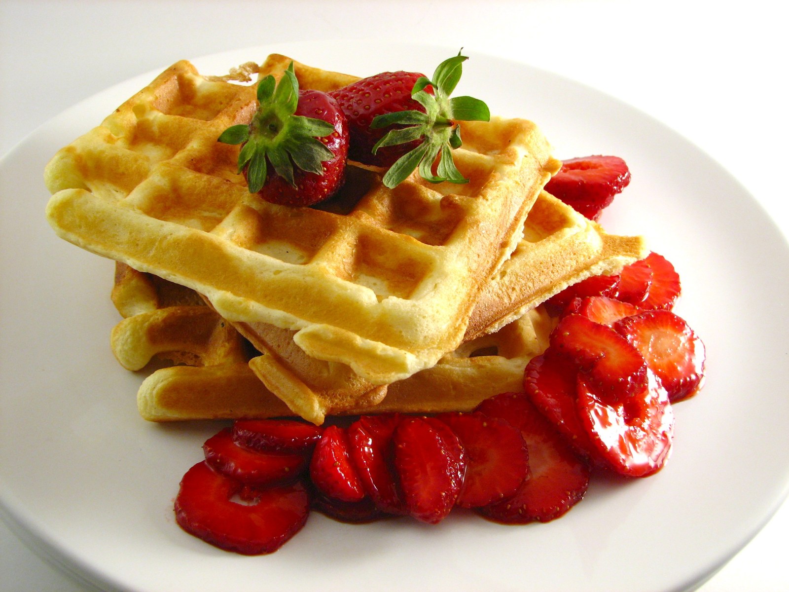 Rechteckige goldene Waffeln mit frischen roten Erdbeeren