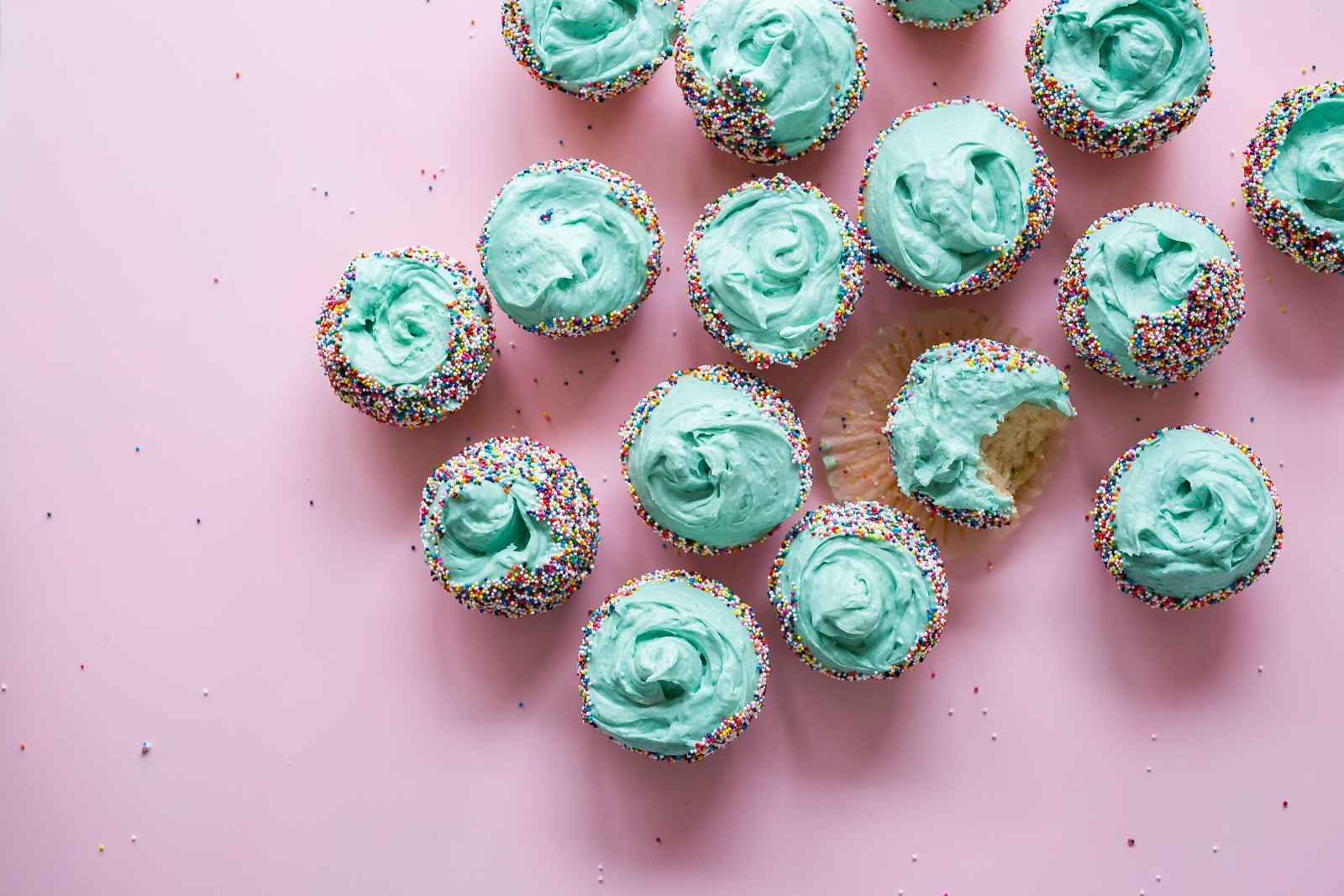 Vanille-Cupcakes mit grüner Buttercreme und bunten Streuseln