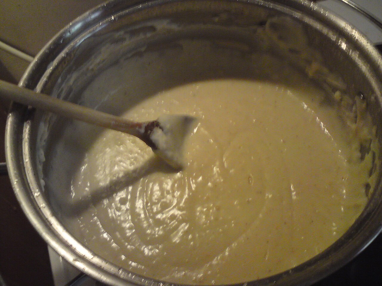 Helle Béchamelsauce in einem Topf mit Holzlöffel
